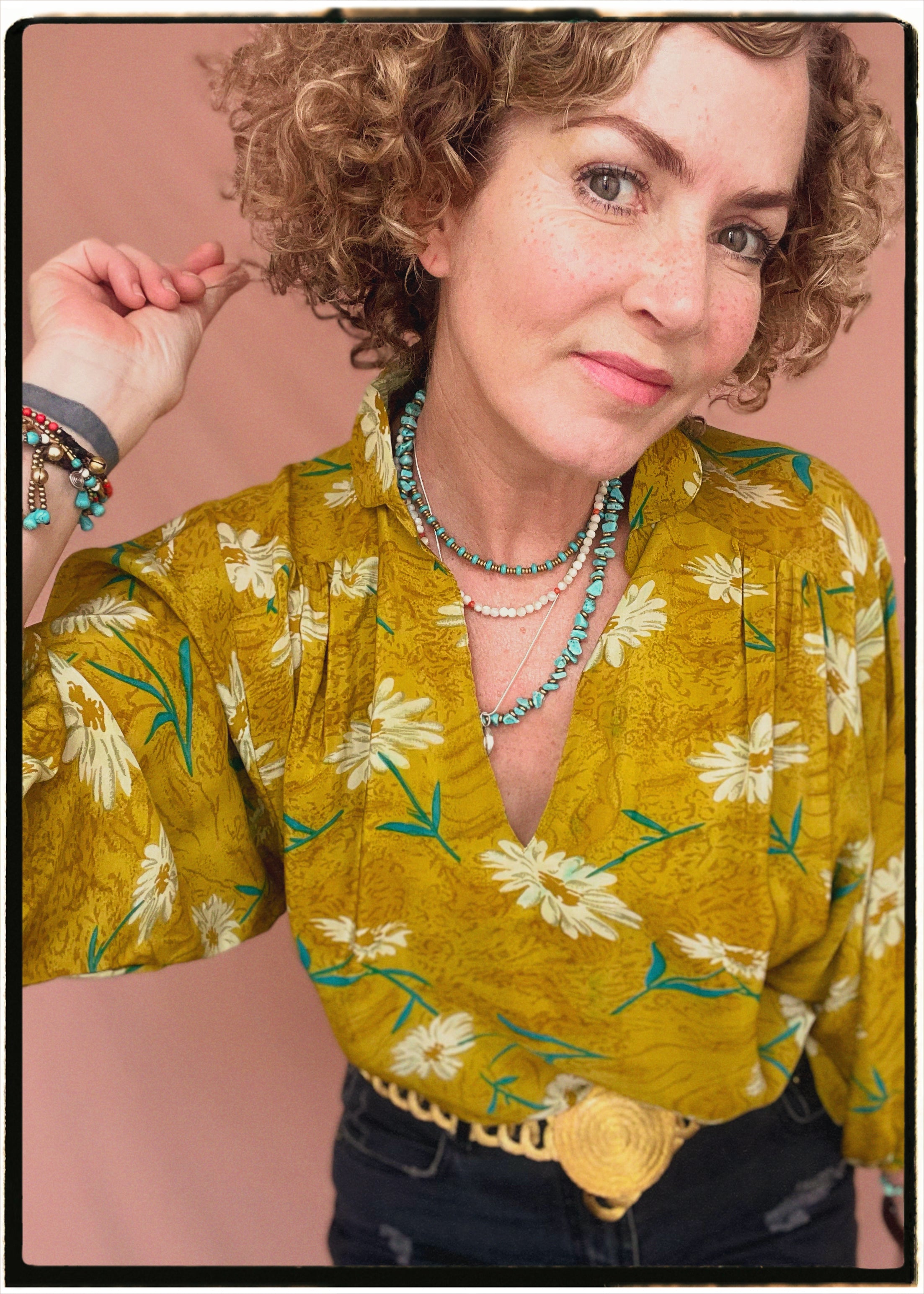 Woman wearing a bohemian style balloon sleeved blouse made from vintage repurposed Indian silk crepe sari in front of a plain background
