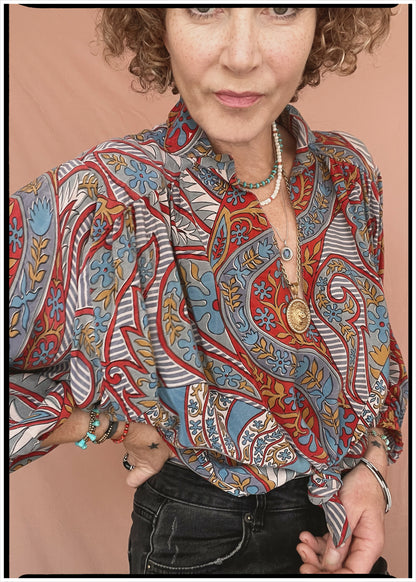 Woman wearing a bohemian style balloon sleeved patterned blouse made from vintage repurposed Indian silk crepe sari in front of a plain background