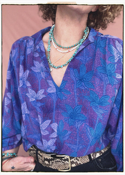 Woman wearing a bohemian style balloon sleeved patterned blouse made from vintage repurposed Indian silk crepe sari in front of a plain background