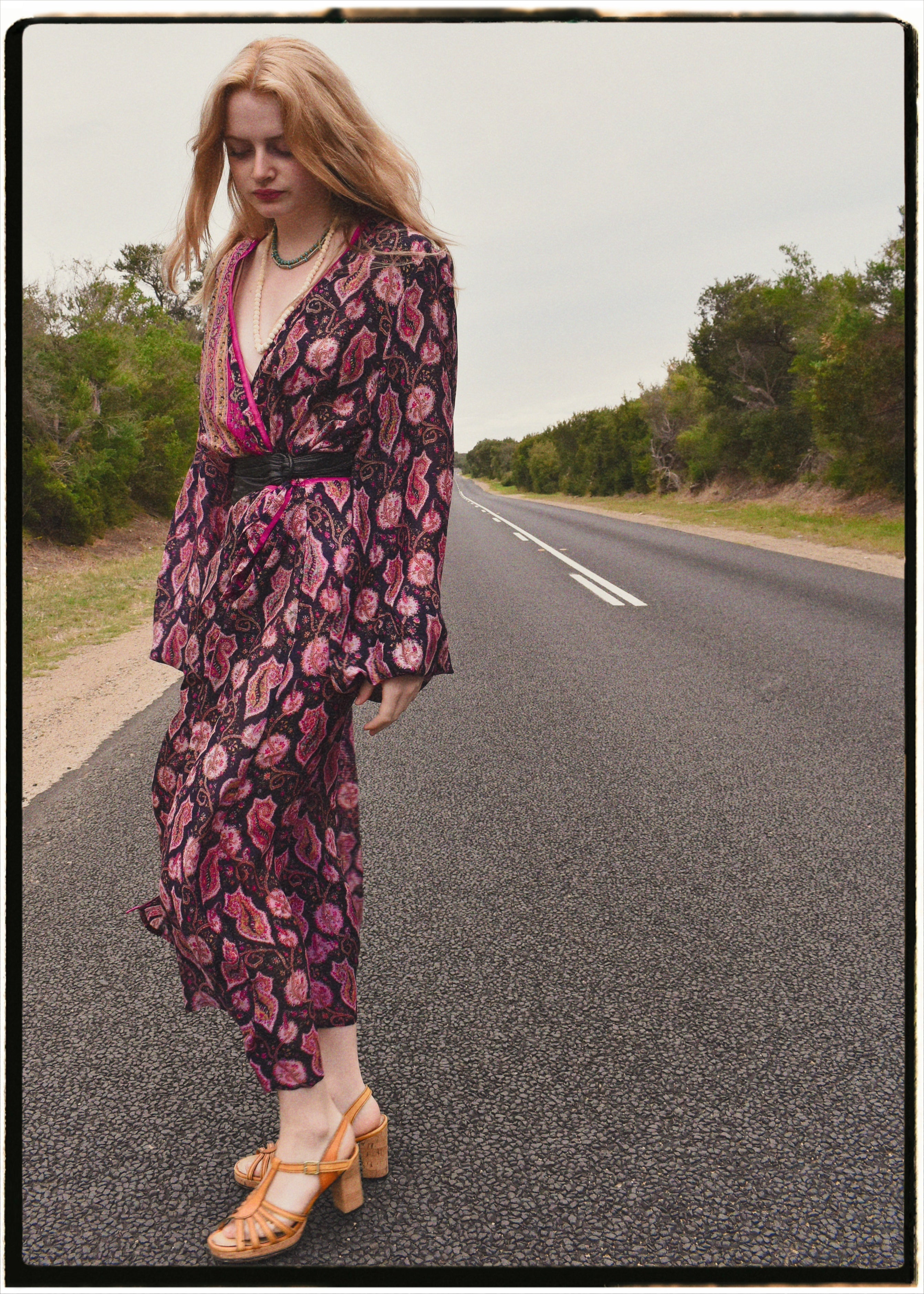 Woman wearing a bohemian style balloon sleeved wrap dress made from vintage repurposed Indian silk crepe sari in front of a plain 
