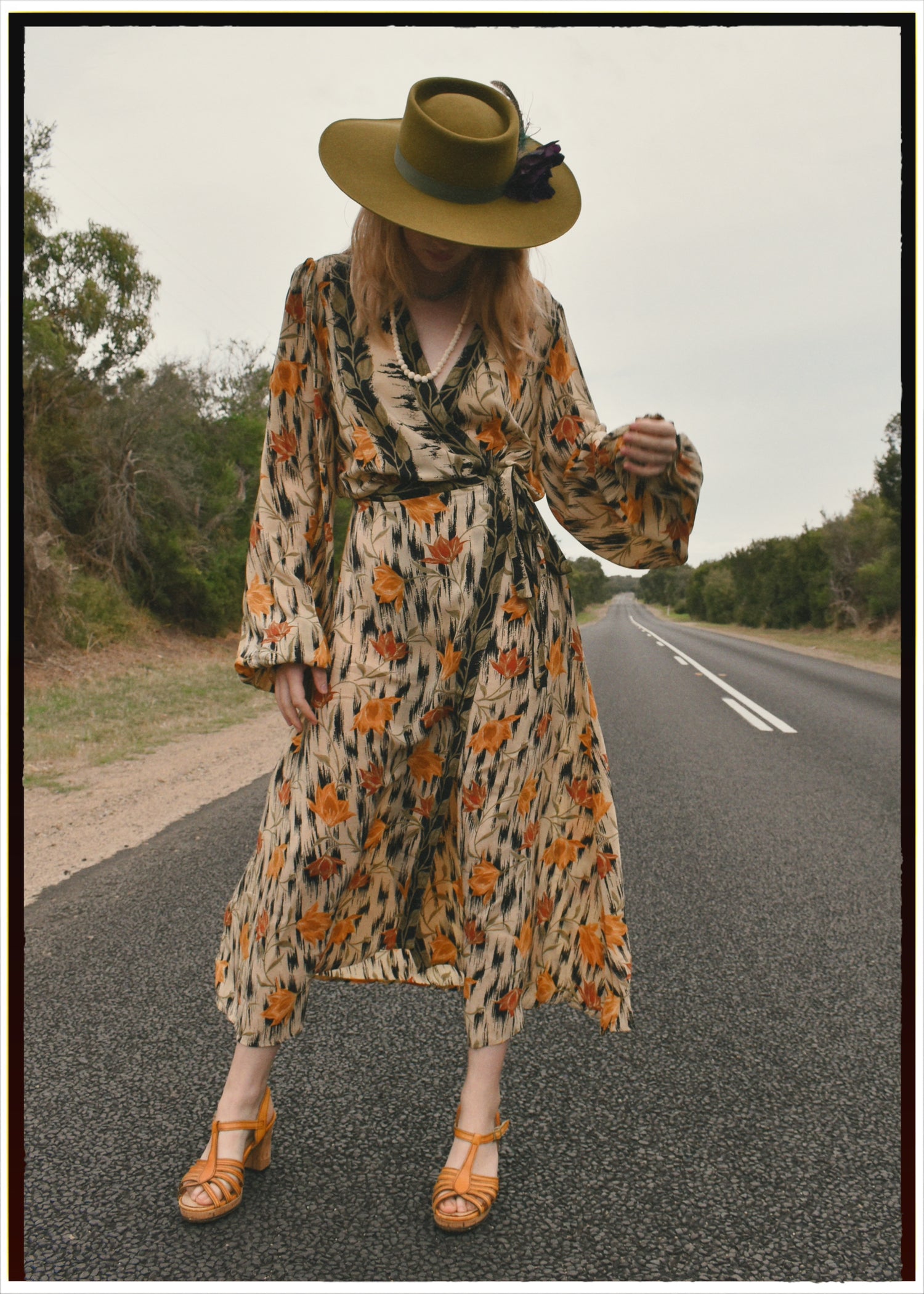Woman wearing a bohemian style balloon sleeved wrap dress made from vintage repurposed Indian silk crepe sari in front of a plain 