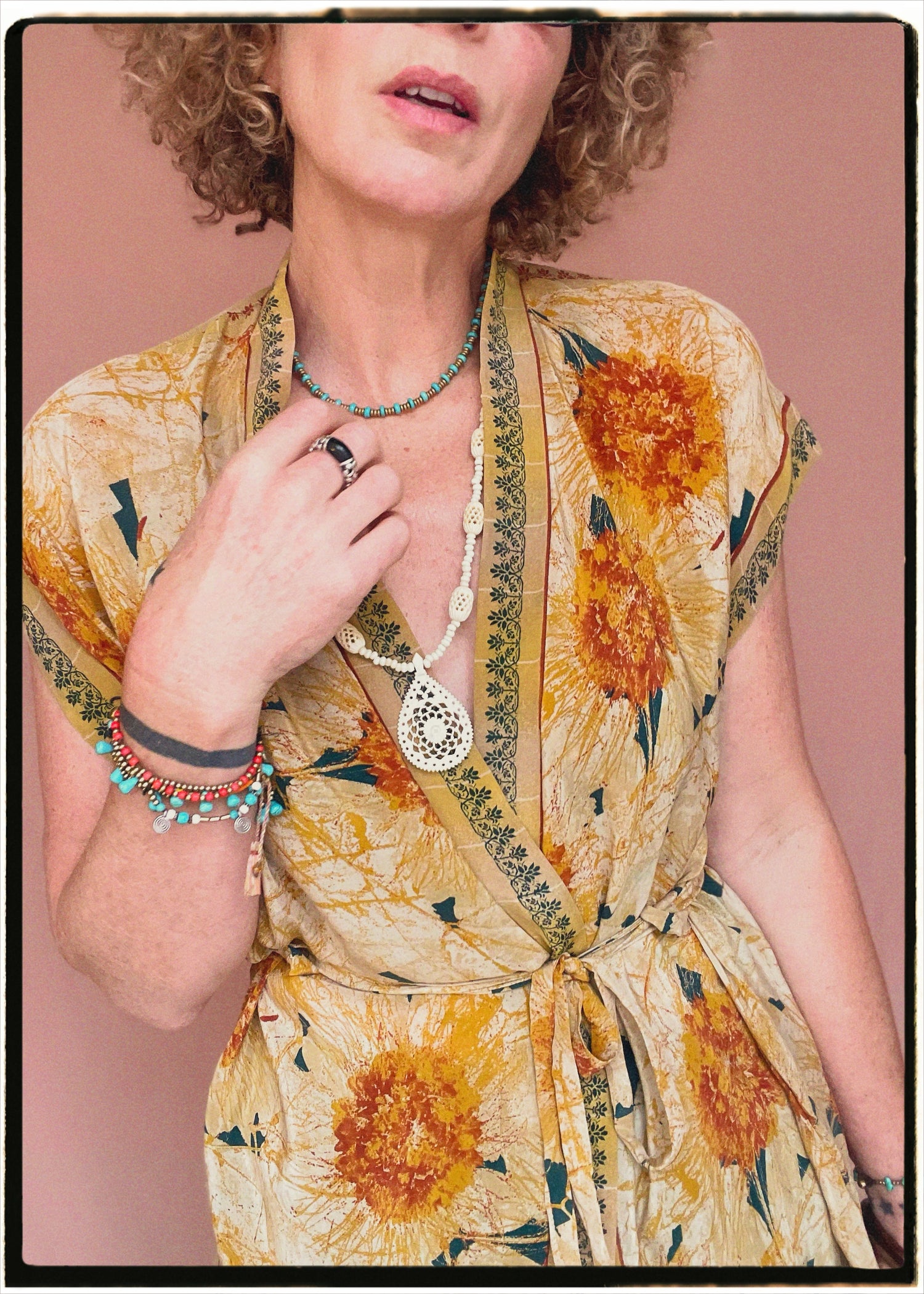 Woman wearing a bohemian style balloon sleeved patterned blouse made from vintage repurposed Indian silk crepe sari in front of a plain background