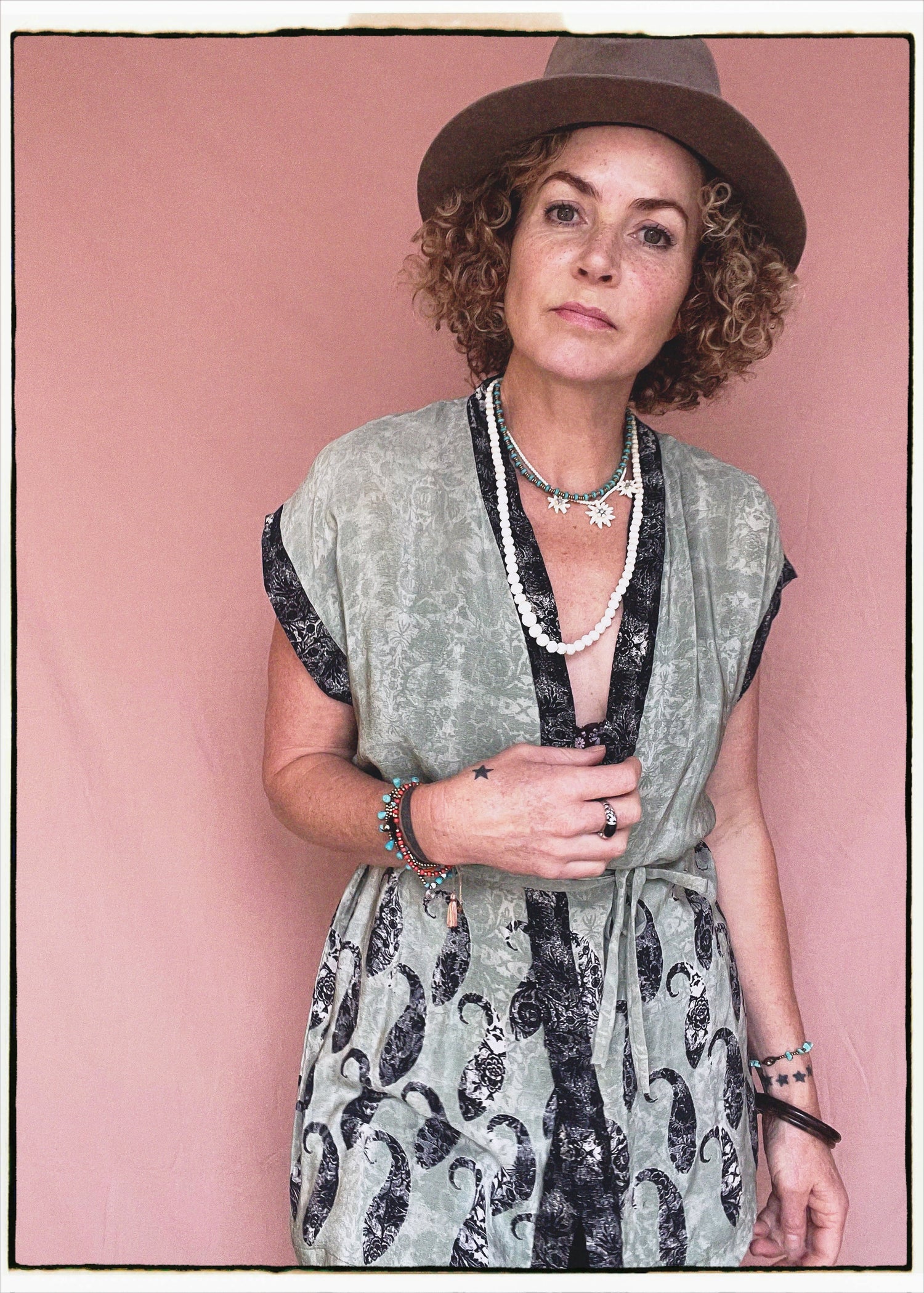 Woman wearing a bohemian style balloon sleeved patterned blouse made from vintage repurposed Indian silk crepe sari in front of a plain background