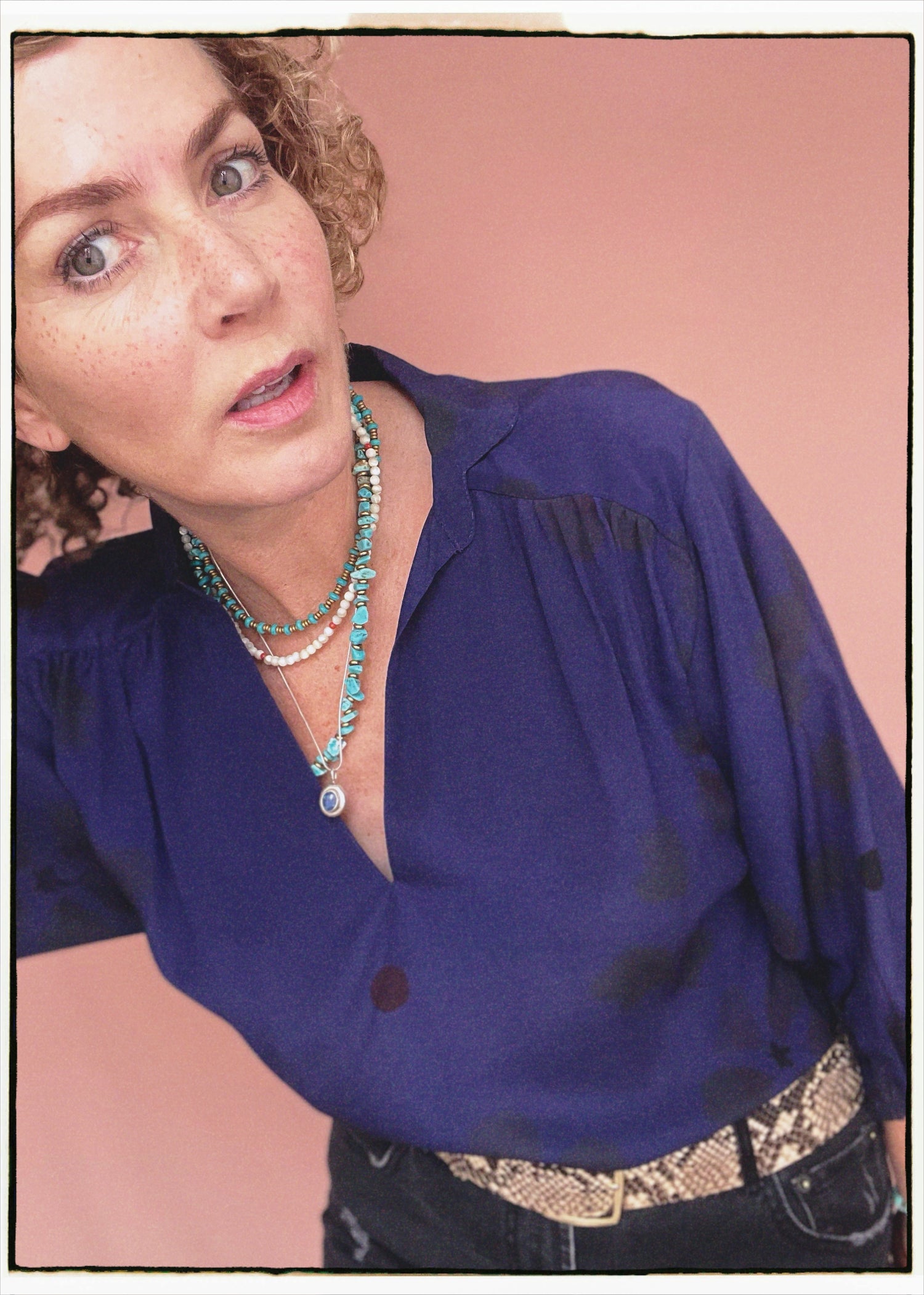 Woman wearing a bohemian style balloon sleeved blouse made from vintage repurposed Indian silk crepe sari in front of a plain background