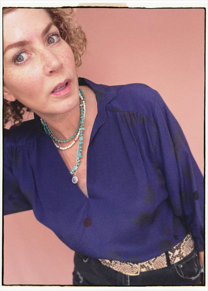 Woman wearing a bohemian style balloon sleeved blouse made from vintage repurposed Indian silk crepe sari in front of a plain background