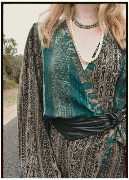 Woman wearing a bohemian style balloon sleeved blouse made from vintage repurposed Indian silk crepe sari in front of a plain background
