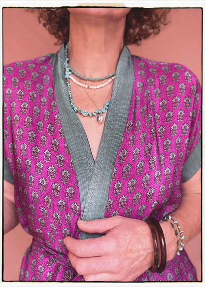Woman wearing a bohemian style balloon sleeved patterned blouse made from vintage repurposed Indian silk crepe sari in front of a plain background