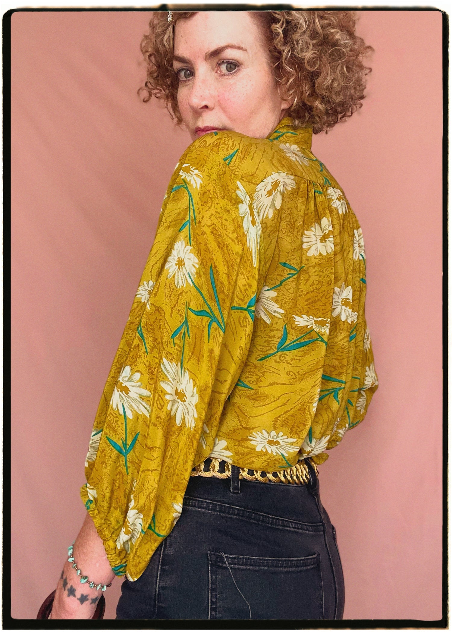 Woman wearing a bohemian style balloon sleeved blouse made from vintage repurposed Indian silk crepe sari in front of a plain background