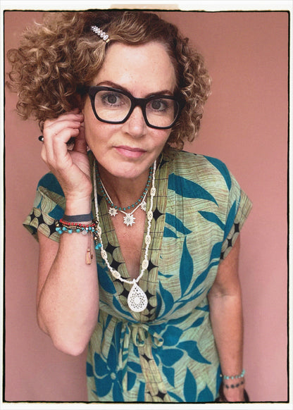 Woman wearing a bohemian style balloon sleeved patterned blouse made from vintage repurposed Indian silk crepe sari in front of a plain background