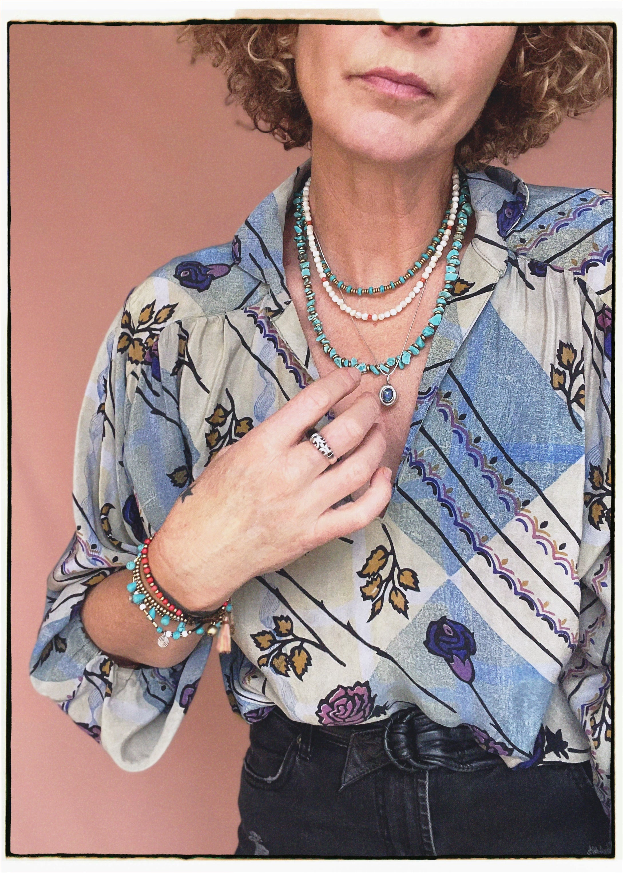 Woman wearing a bohemian style balloon sleeved patterned blouse made from vintage repurposed Indian silk crepe sari in front of a plain background