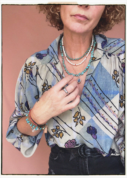 Woman wearing a bohemian style balloon sleeved patterned blouse made from vintage repurposed Indian silk crepe sari in front of a plain background