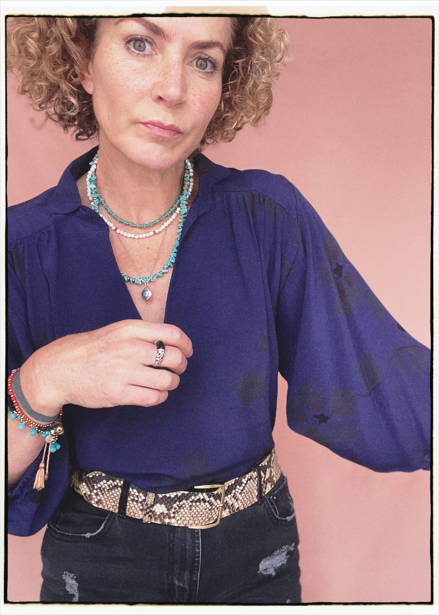 Woman wearing a bohemian style balloon sleeved blouse made from vintage repurposed Indian silk crepe sari in front of a plain background