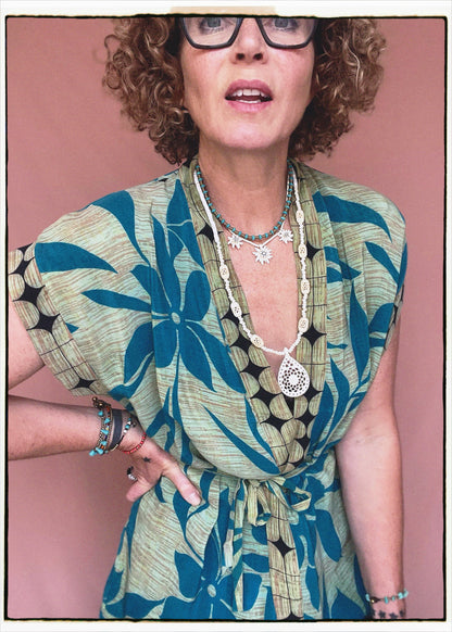 Woman wearing a bohemian style balloon sleeved patterned blouse made from vintage repurposed Indian silk crepe sari in front of a plain background