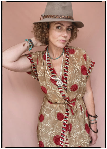 Woman wearing a bohemian style balloon sleeved patterned blouse made from vintage repurposed Indian silk crepe sari in front of a plain background