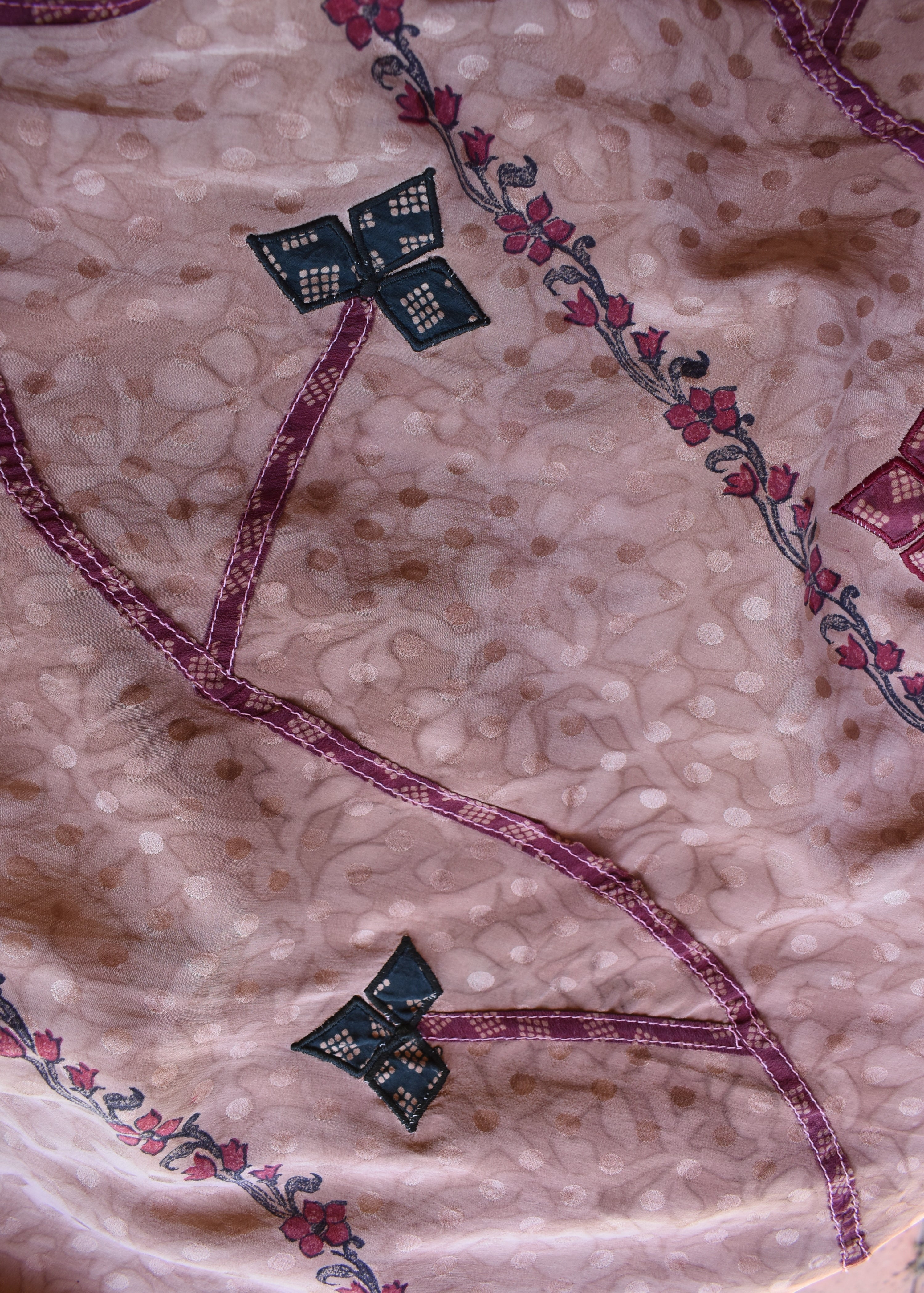 Decorative fabric with embroidered patterns on a beige background