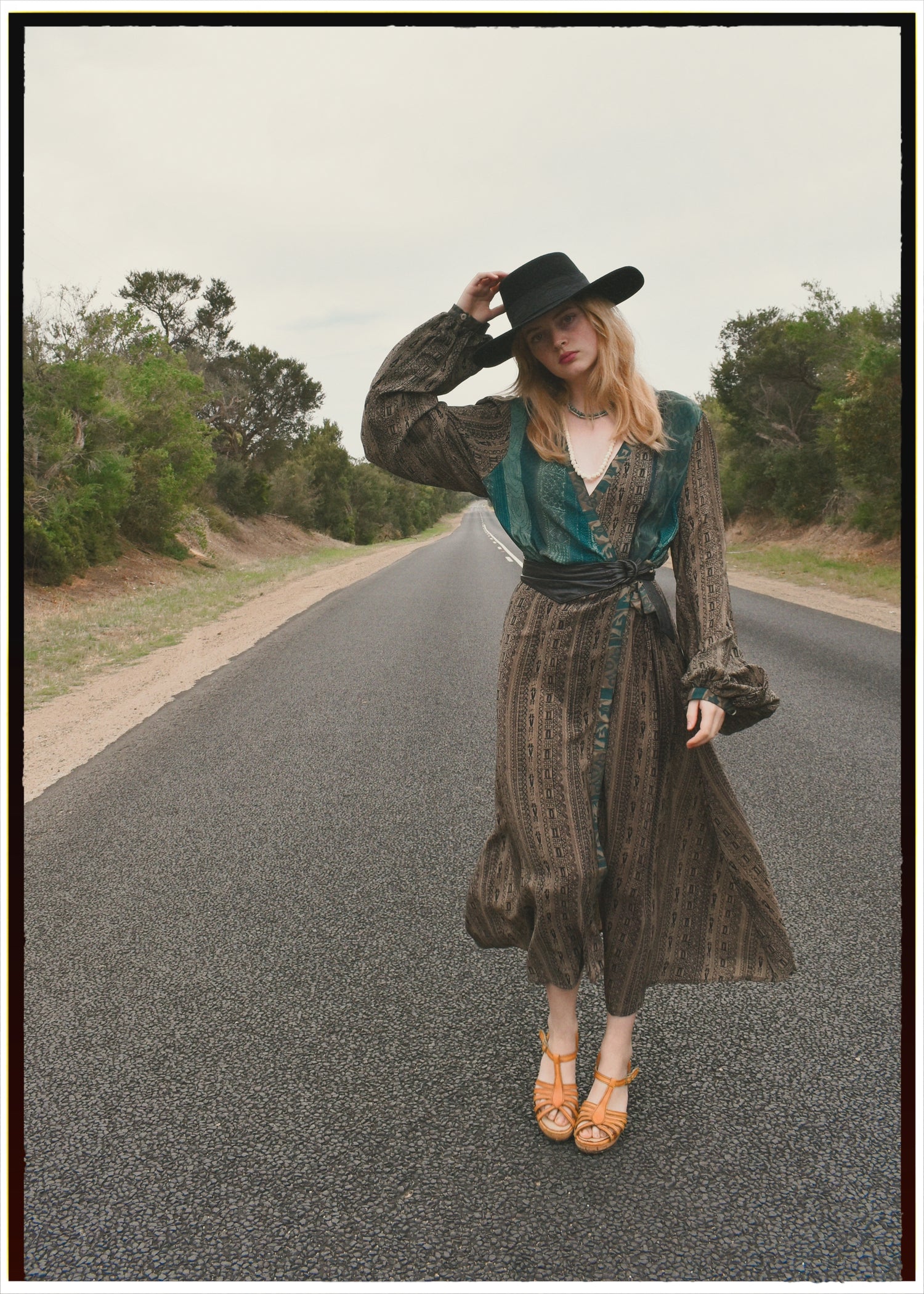 Woman wearing a bohemian style balloon sleeved wrap dress made from vintage repurposed Indian silk crepe sari in front of a plain background