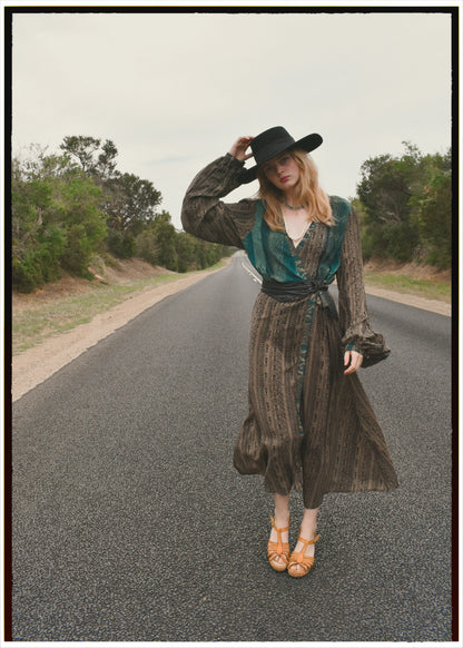 Woman wearing a bohemian style balloon sleeved wrap dress made from vintage repurposed Indian silk crepe sari in front of a plain background
