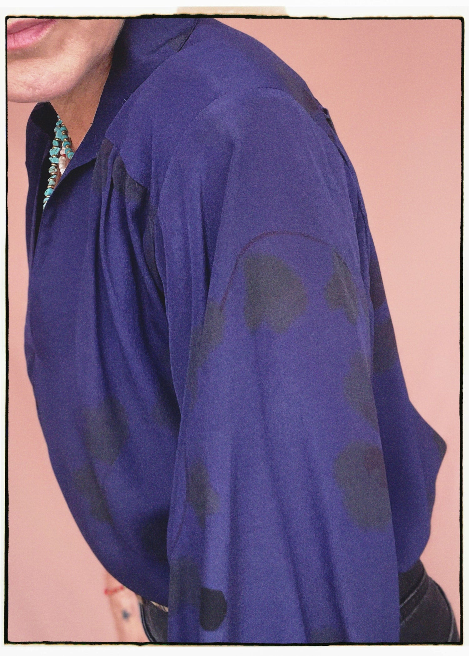 Woman wearing a bohemian style balloon sleeved blouse made from vintage repurposed Indian silk crepe sari in front of a plain background